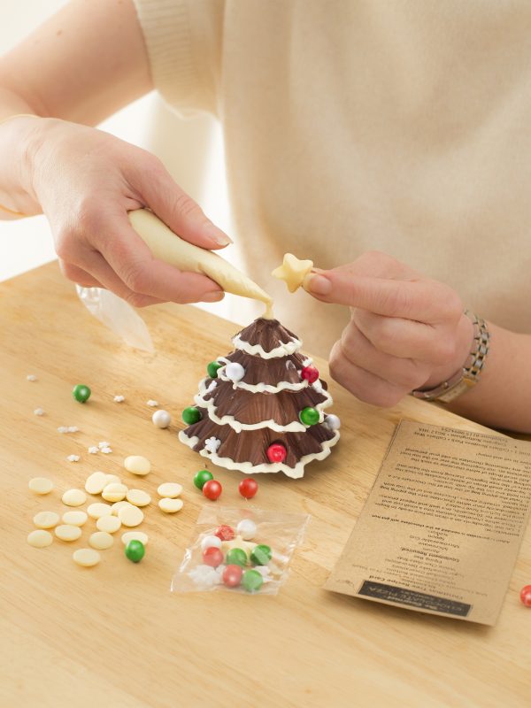 chocolate Christmas tree being hand decorated